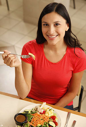 Mujer comiendo ensalada.